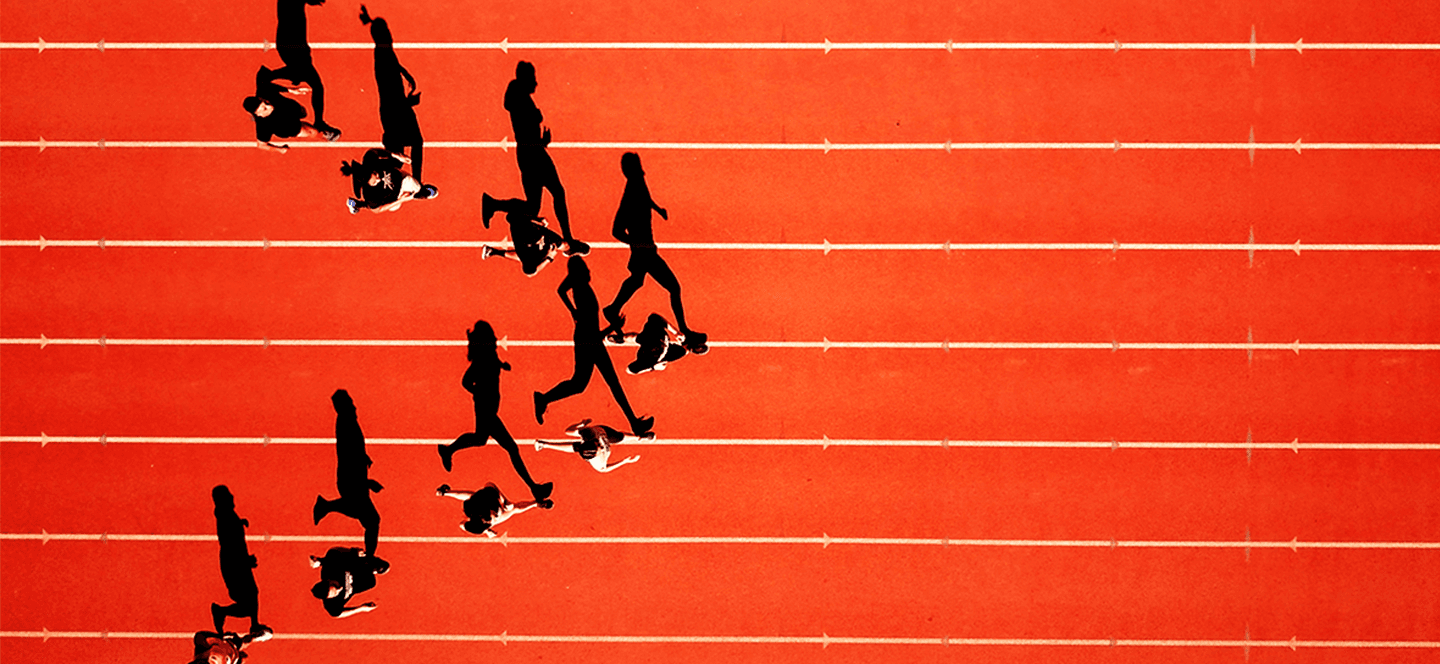 Eight people running on an Athletics track in a triangle formation