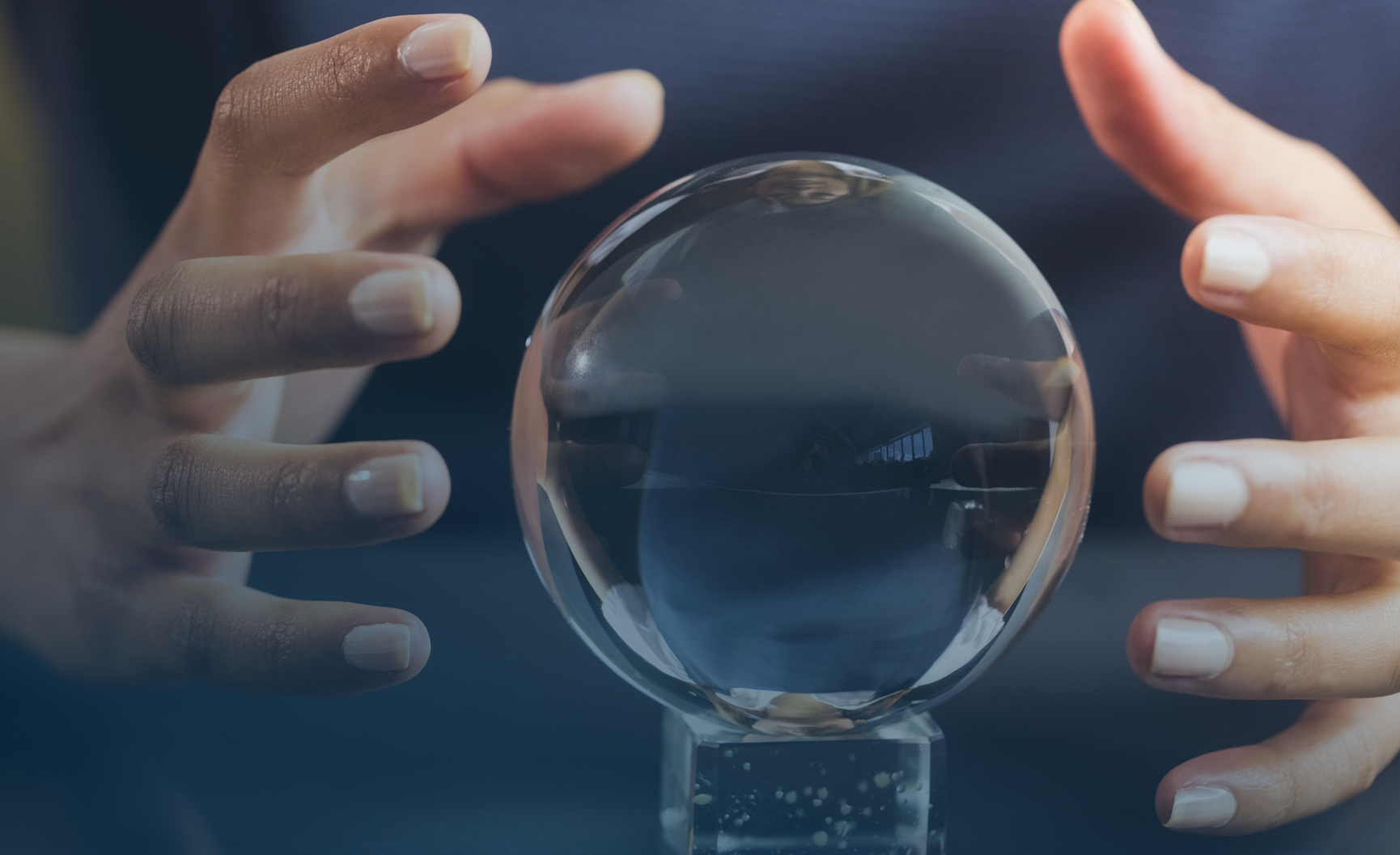 Hands hovering around a crystal ball